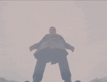 a man in a hat is laying in the snow with his hands outstretched