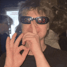 a person wearing sunglasses that say ss 03