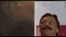 a man with a mustache is standing in front of a red ctc logo