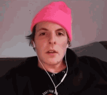 a man wearing a pink beanie and headphones