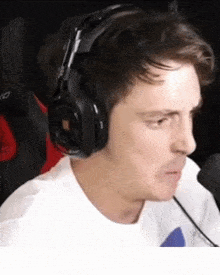 a man wearing headphones and a white shirt is looking at the camera .