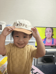 a little girl is wearing a hat that says nope