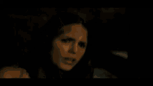 a woman with a scar on her face is looking at the camera
