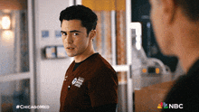 a man in a chicago medical center scrub is looking at another man