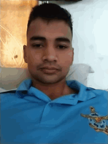 a man wearing a blue polo shirt with a turtle on the front