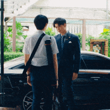 a man in a suit and tie stands next to another man