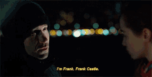 a man in a hooded jacket says i 'm frank frank castle while a woman looks on