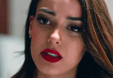 a close up of a woman 's face with red lipstick on .