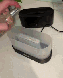 a person is spraying perfume on a device that says ' sss ' on the side