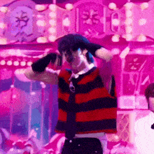 a man in a red and black striped shirt and tie is dancing in front of a crowd .
