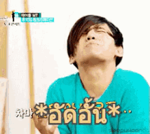 a man in a blue shirt is making a funny face with chinese writing behind him