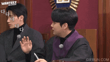 a man in a purple robe is sitting in front of a sign that says ' wanteez job special '