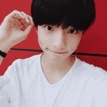 a young boy taking a selfie with his hand in his hair