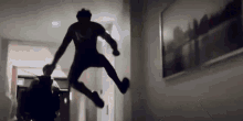 a silhouette of a man jumping in the air