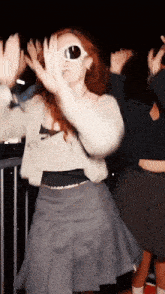a woman wearing sunglasses is dancing in a crowd with her hands in the air