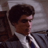 a man in a suit and tie is looking at something