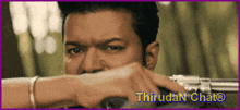 a close up of a man holding a gun with a purple border that says thiruran chat