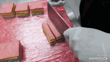 a person is cutting candy on a cutting board with the words made in animotica visible