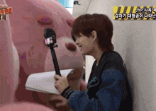 a man is holding a microphone in front of a stuffed animal with a sign that says jyp