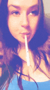 a woman in a blue shirt is holding a lollipop