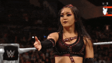 a woman in a wrestling ring giving a thumbs down sign