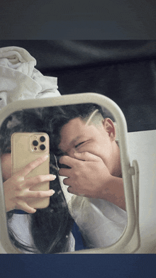 a man and a woman are taking a picture of themselves in the mirror