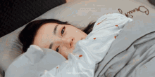 a woman is laying in bed with a pillow that says " beauty " on it