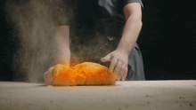 a person kneading dough with a lot of flour