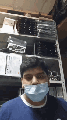a man wearing a mask stands in front of a shelf with a box that says ' lg ' on it