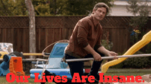 a man kneeling down in front of a slide with the words our lives are insane