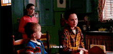 a boy in a plaid shirt is sitting at a table saying i hate it
