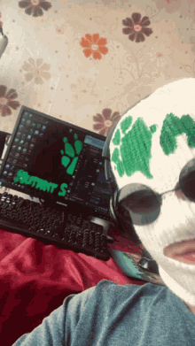 a person wearing a ski mask is sitting in front of a computer screen that says " recruitment s "