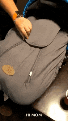 a person is holding a stroller cover that says hi mom on it