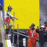 a man taking a picture of a motorcycle racer wearing a jersey that says fra
