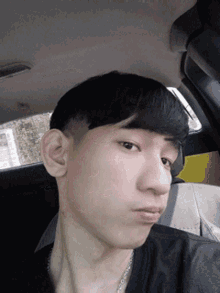 a young man in a car taking a selfie