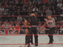 a man in a black shirt that says " it factor " is wrestling another man in a black shirt