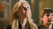 a woman and a boy look up at something