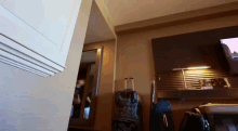 a hotel room with a suitcase and a tv on the wall