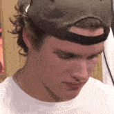 a close up of a man wearing a hat and a necklace
