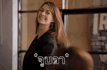 a woman is smiling and looking at the camera in a room with a foreign language .