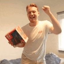 a man in a white shirt is holding a book that has the number 17 on the cover