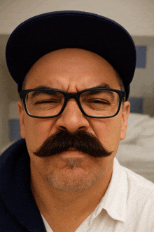 a man with glasses and a mustache makes a face
