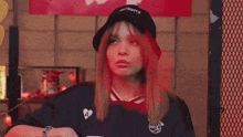 a woman wearing a bucket hat and a jersey with the number 9 on it covering her mouth