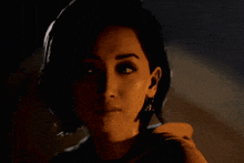 a close up of a woman 's face with dark hair and earrings