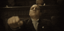 a man in a suit giving the middle finger