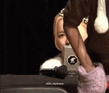 a person with a sticker on their phone that says dc_mydream on it