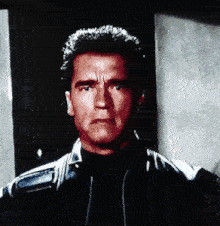 arnold schwarzenegger is wearing a black jacket and a black shirt