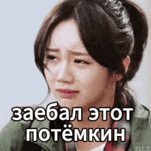 a woman with a ponytail is making a sad face with a caption in russian .