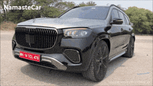 a black mercedes with a red license plate that says mh 14 tcl 476