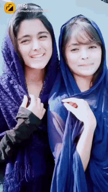 two girls are posing for a picture and one has a purple scarf around her head